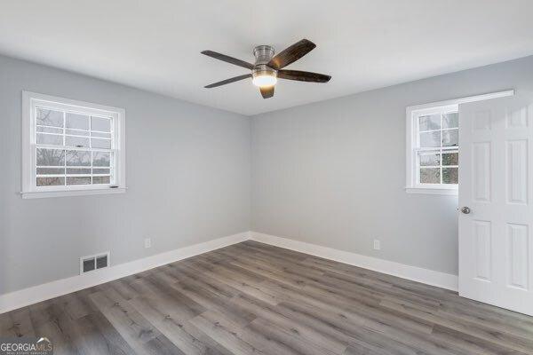 spare room with dark hardwood / wood-style flooring and ceiling fan