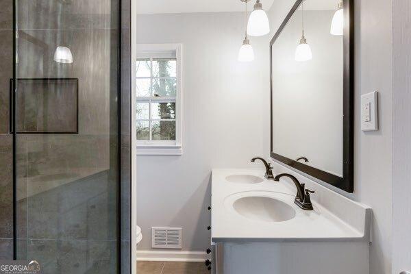 bathroom featuring tile patterned floors, vanity, and an enclosed shower