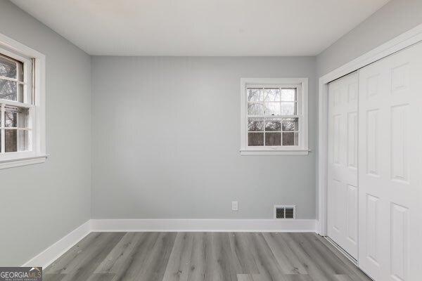 unfurnished bedroom featuring light hardwood / wood-style flooring and a closet