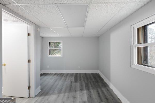 spare room featuring dark wood-type flooring and a paneled ceiling