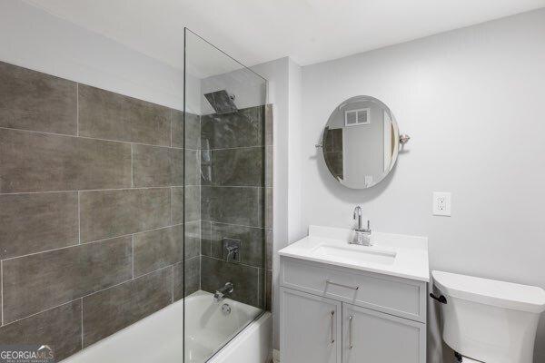 full bathroom featuring vanity, toilet, and tiled shower / bath