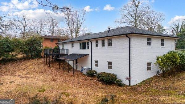 back of property with central AC and a deck