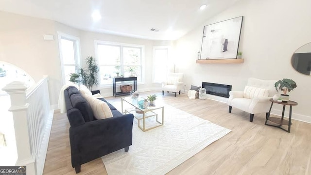 living room featuring vaulted ceiling and light wood-type flooring