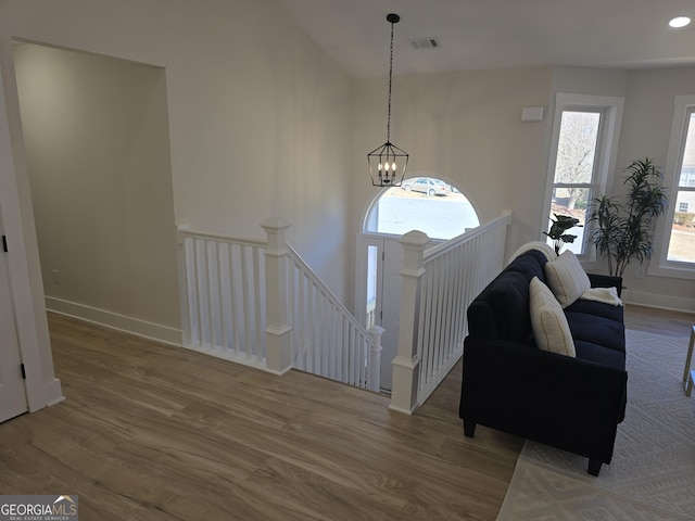 foyer entrance with hardwood / wood-style floors and a notable chandelier