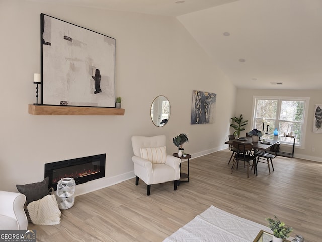 living area featuring lofted ceiling and light wood-type flooring