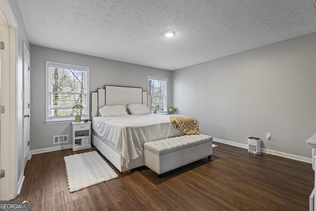 bedroom featuring dark hardwood / wood-style floors and a textured ceiling