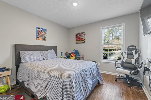 bedroom with dark hardwood / wood-style floors and a textured ceiling