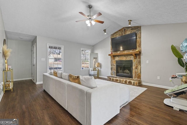 living room featuring dark hardwood / wood-style flooring, a fireplace, ceiling fan, and vaulted ceiling