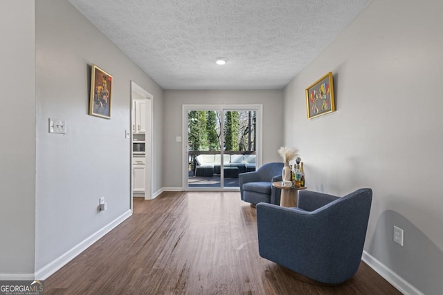 living area featuring hardwood / wood-style floors and a textured ceiling