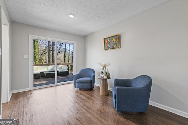 sitting room with dark hardwood / wood-style flooring and a textured ceiling