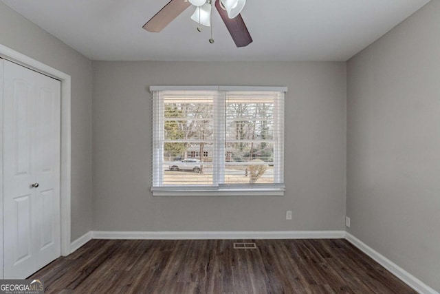 empty room with dark hardwood / wood-style floors and ceiling fan