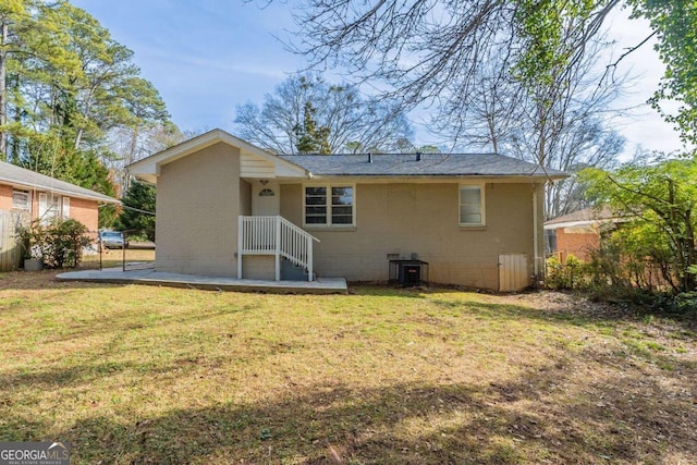 rear view of property featuring a lawn