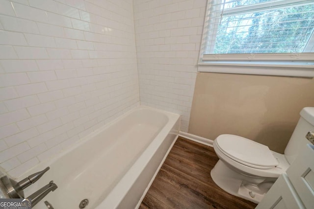 bathroom featuring hardwood / wood-style flooring, a bath, and toilet