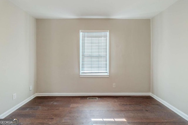 empty room with dark hardwood / wood-style flooring