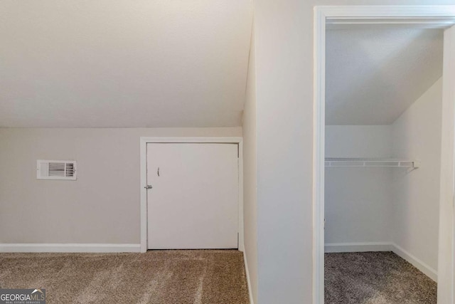 additional living space with carpet floors and vaulted ceiling