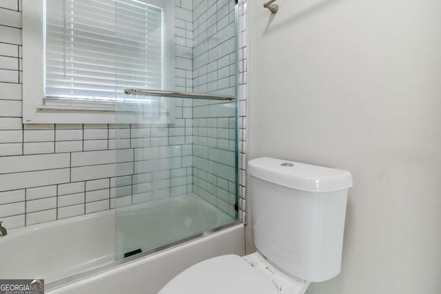 bathroom featuring enclosed tub / shower combo and toilet