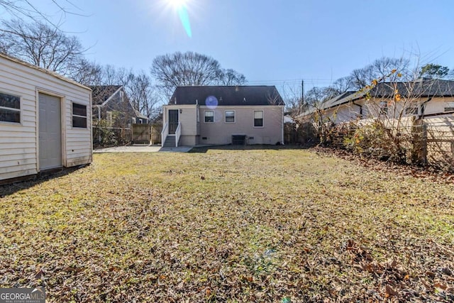 rear view of house with a patio, an outdoor structure, and a yard