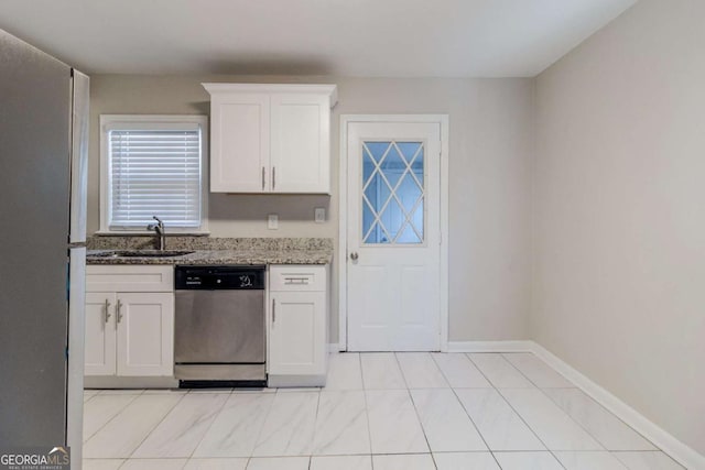 kitchen featuring dark stone counters, dishwasher, sink, and white cabinets