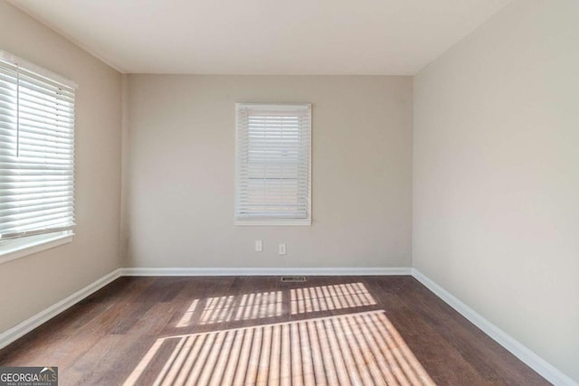 empty room with dark wood-type flooring