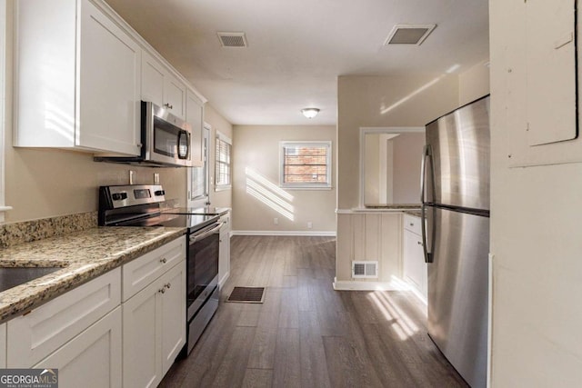 kitchen featuring light stone counters, appliances with stainless steel finishes, dark hardwood / wood-style flooring, and white cabinets