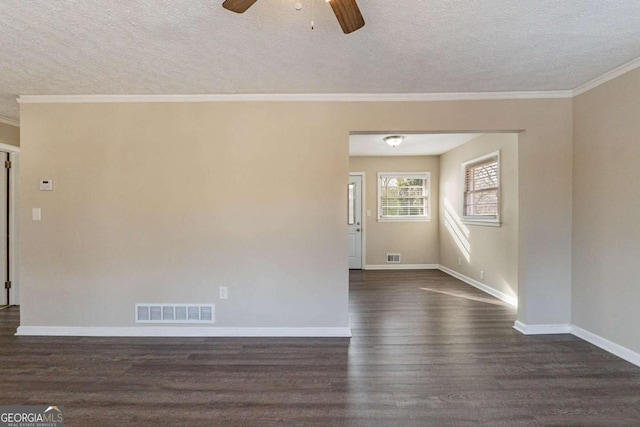 spare room with crown molding, dark wood-type flooring, and a textured ceiling