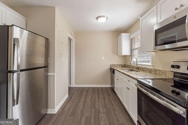 kitchen with light stone counters, sink, white cabinets, and appliances with stainless steel finishes