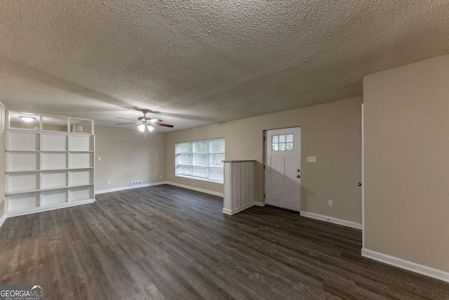 unfurnished living room featuring ceiling fan, dark wood-type flooring, and a textured ceiling