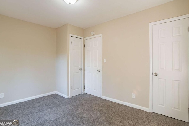 unfurnished bedroom featuring dark carpet