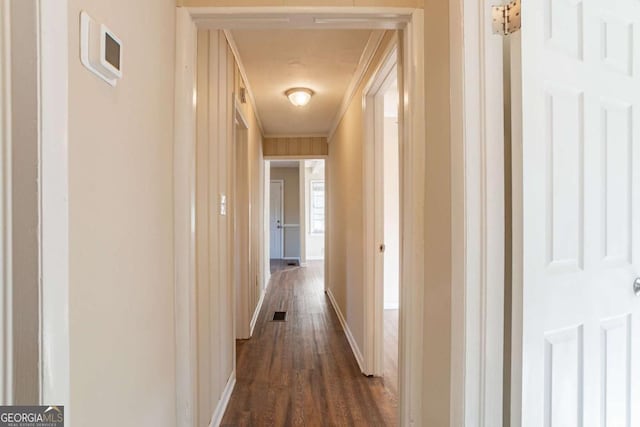 hallway with ornamental molding and dark hardwood / wood-style flooring