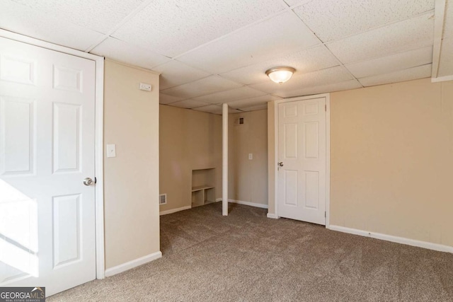 basement featuring carpet flooring and a drop ceiling