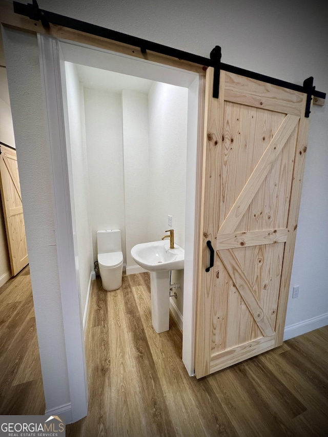 bathroom featuring sink, wood-type flooring, and toilet