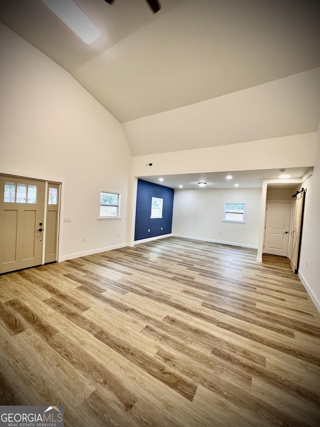 unfurnished living room featuring lofted ceiling and light wood-type flooring