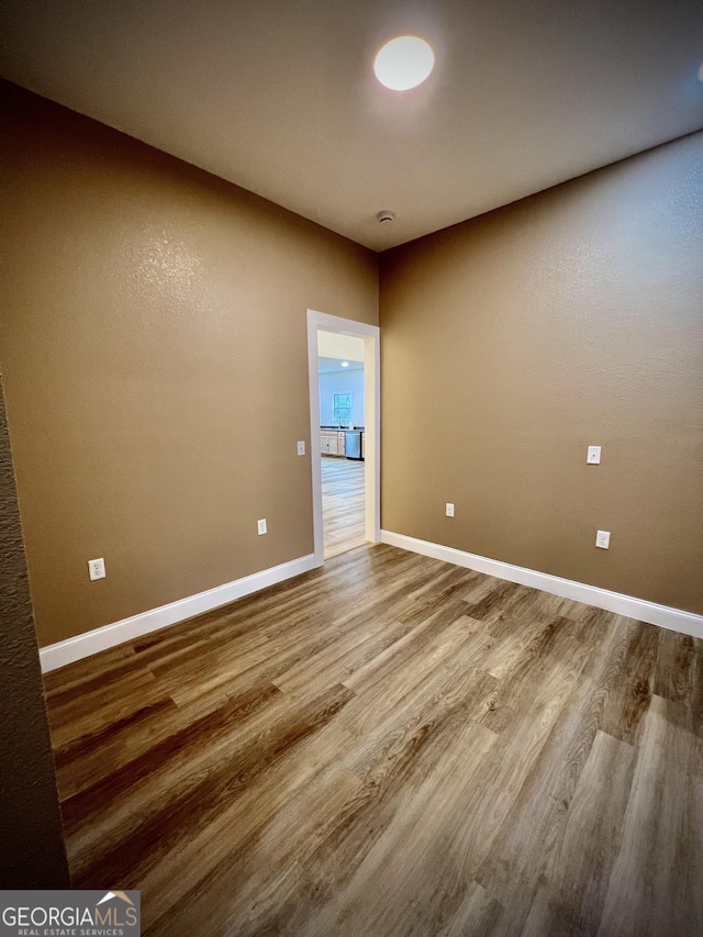 unfurnished room with wood-type flooring