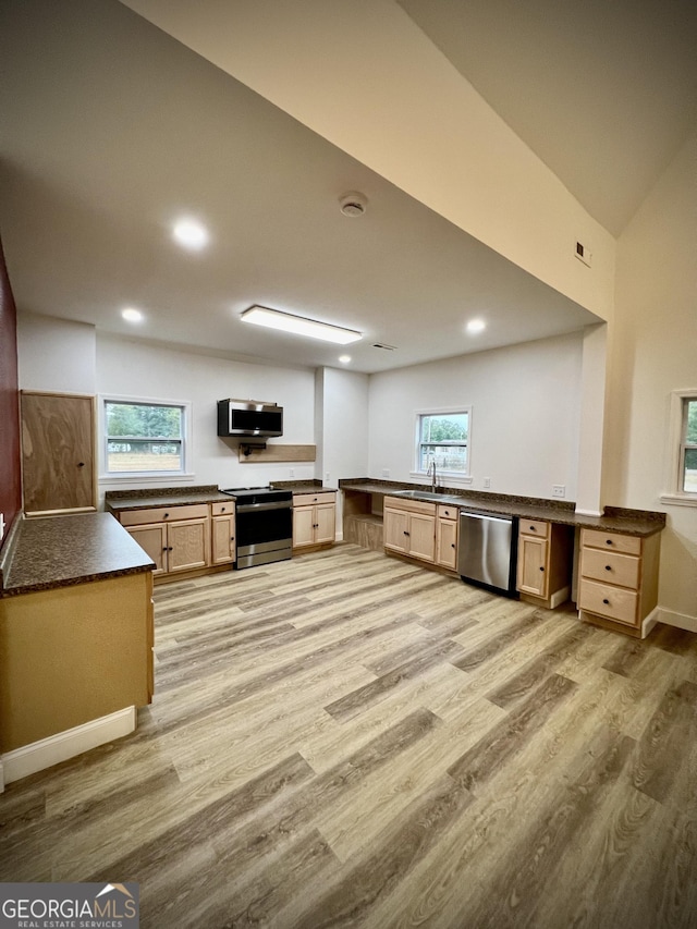 kitchen featuring stainless steel appliances, built in desk, sink, and kitchen peninsula