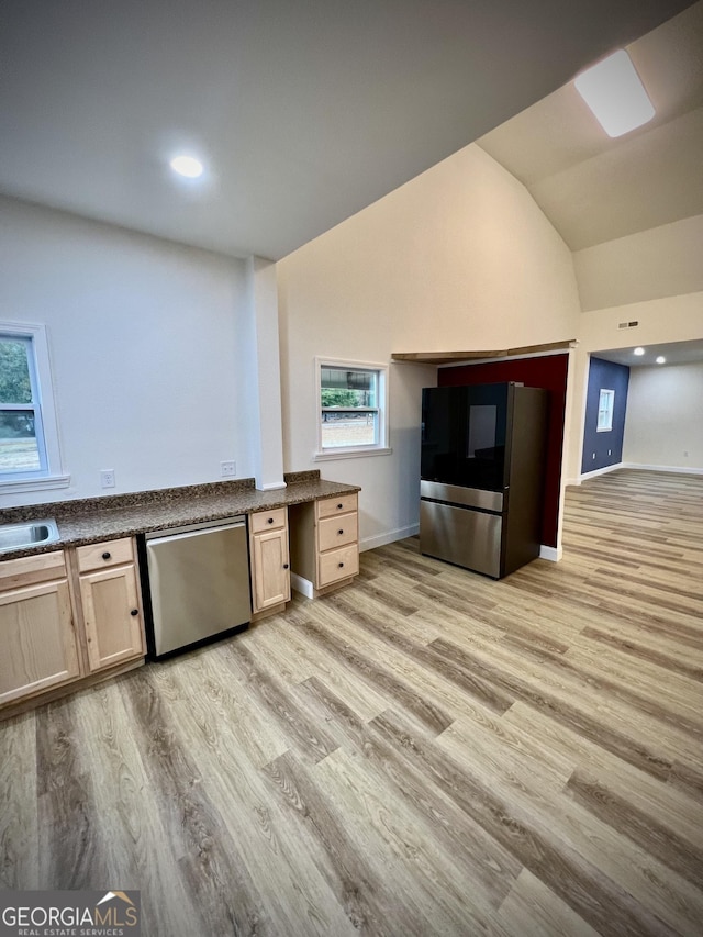 kitchen with lofted ceiling, light wood-type flooring, light brown cabinets, and appliances with stainless steel finishes