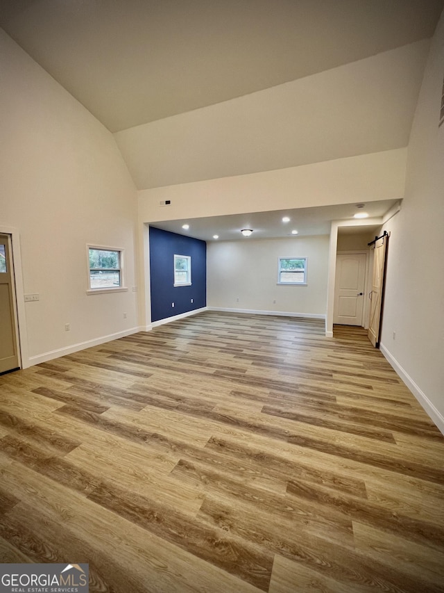 unfurnished living room with lofted ceiling and light wood-type flooring