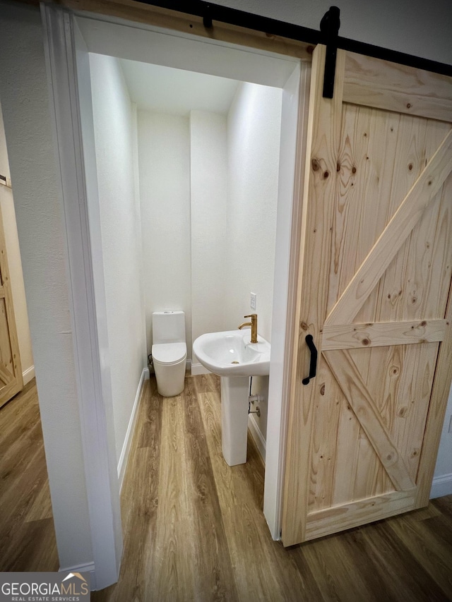 bathroom with hardwood / wood-style flooring and toilet