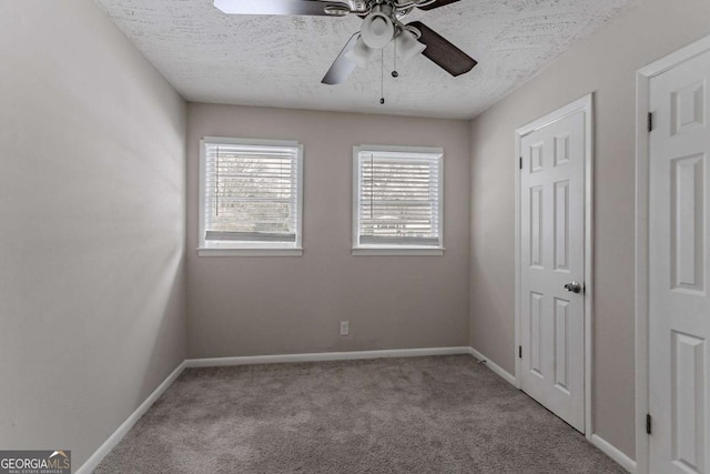 unfurnished bedroom with light colored carpet, a textured ceiling, and ceiling fan