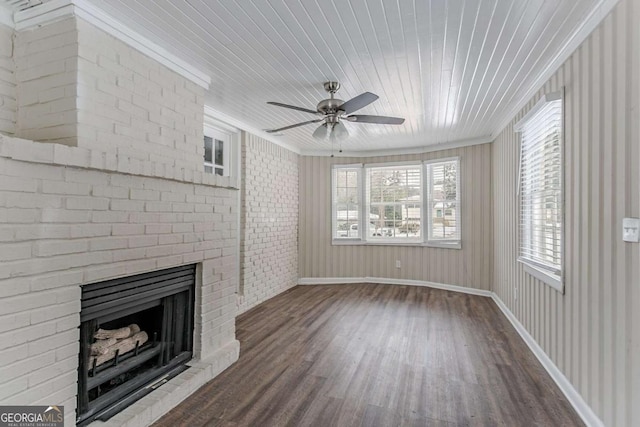 unfurnished living room with crown molding, ceiling fan, wood-type flooring, and a fireplace