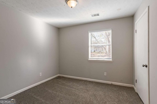 carpeted spare room featuring a textured ceiling