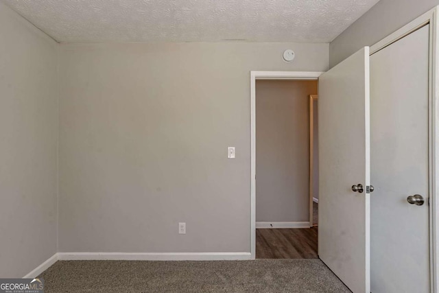 unfurnished bedroom with a textured ceiling and carpet flooring