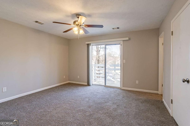 carpeted empty room featuring ceiling fan and a textured ceiling