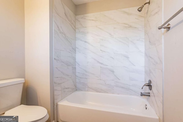 bathroom with tiled shower / bath combo and toilet