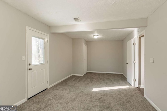 carpeted empty room featuring a textured ceiling