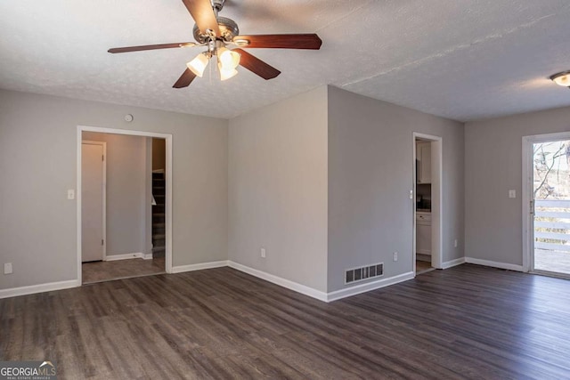 spare room with ceiling fan, a textured ceiling, and dark hardwood / wood-style flooring