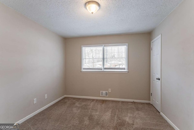 carpeted spare room featuring a textured ceiling