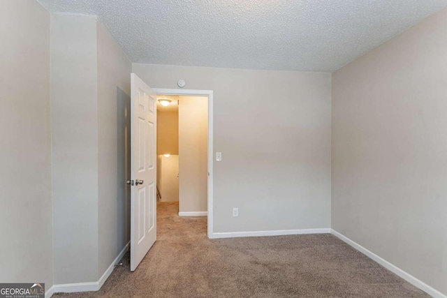 carpeted spare room with a textured ceiling