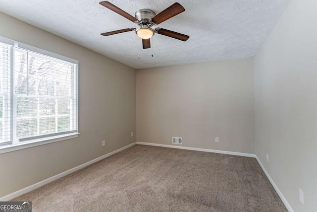 spare room with ceiling fan, carpet floors, and a textured ceiling