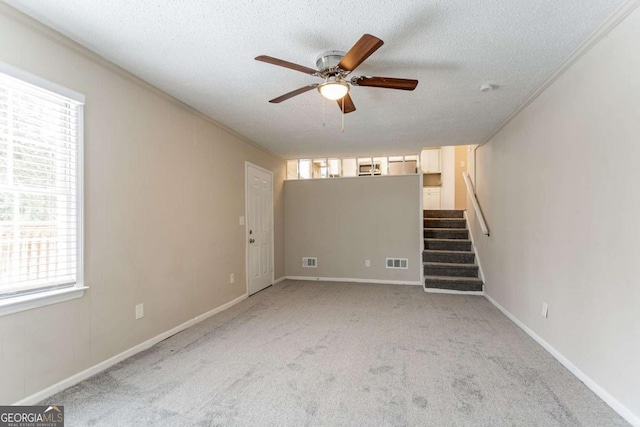 interior space with crown molding, ceiling fan, a textured ceiling, and a healthy amount of sunlight