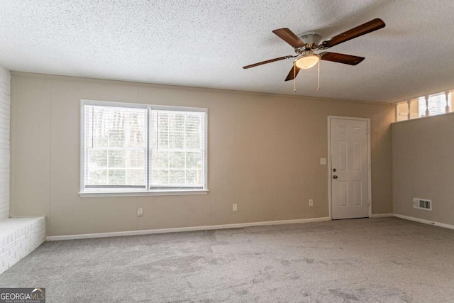 carpeted spare room featuring ceiling fan and a textured ceiling